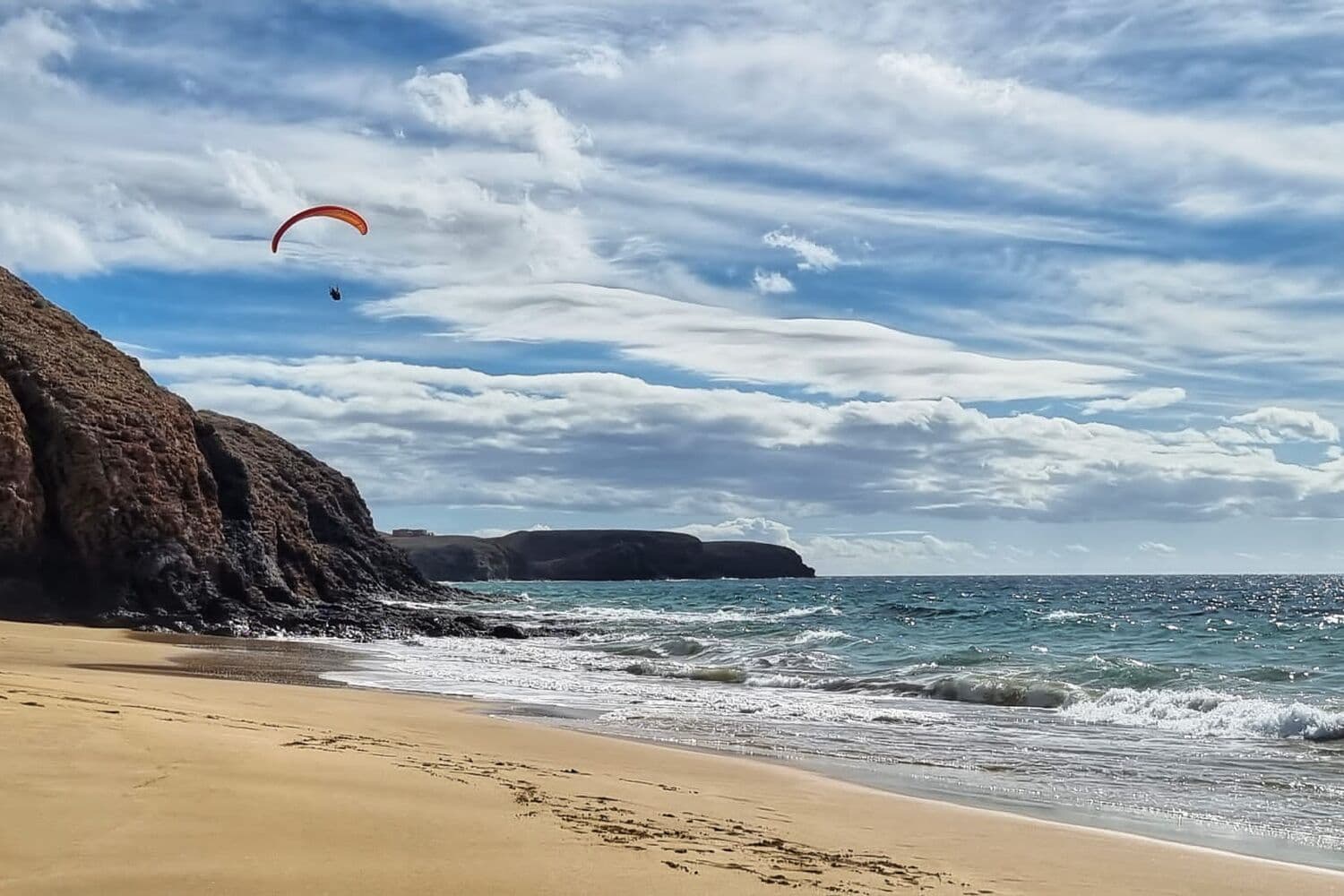 A paraglider above the cliffs at Papagayo beach, in the south of Lanzarote