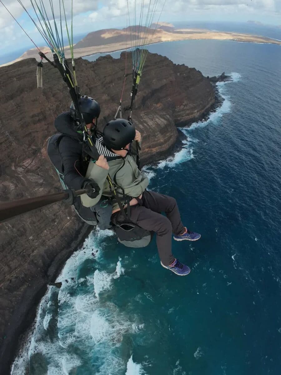 A tandem flight above the northern cliffs, with La Graciosa below