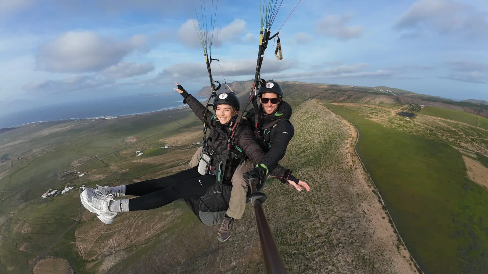 A tandem passenger pointing out the view over Lanzarote's cliffs